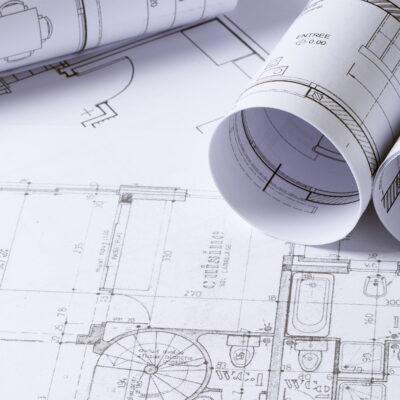 Rolls of plan printing laid on a flat printout of a plan